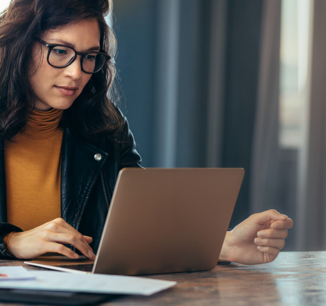 Woman researching how to become a life coach in the UK on her laptop