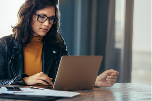 Woman researching how to become a life coach in the UK on her laptop