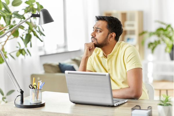 Man at laptop thinking about how long it takes to become a life coach
